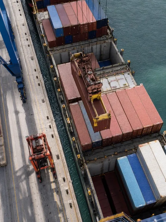 Cẩu bờ hạ container xuống tàu đang cập cầu