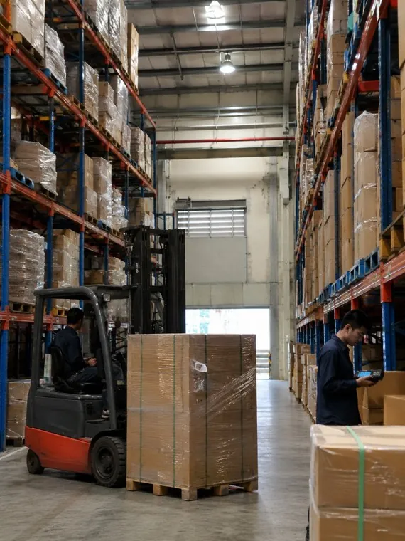 Kho phân phối với giá kệ cao và xe nâng lúc sáng sớm